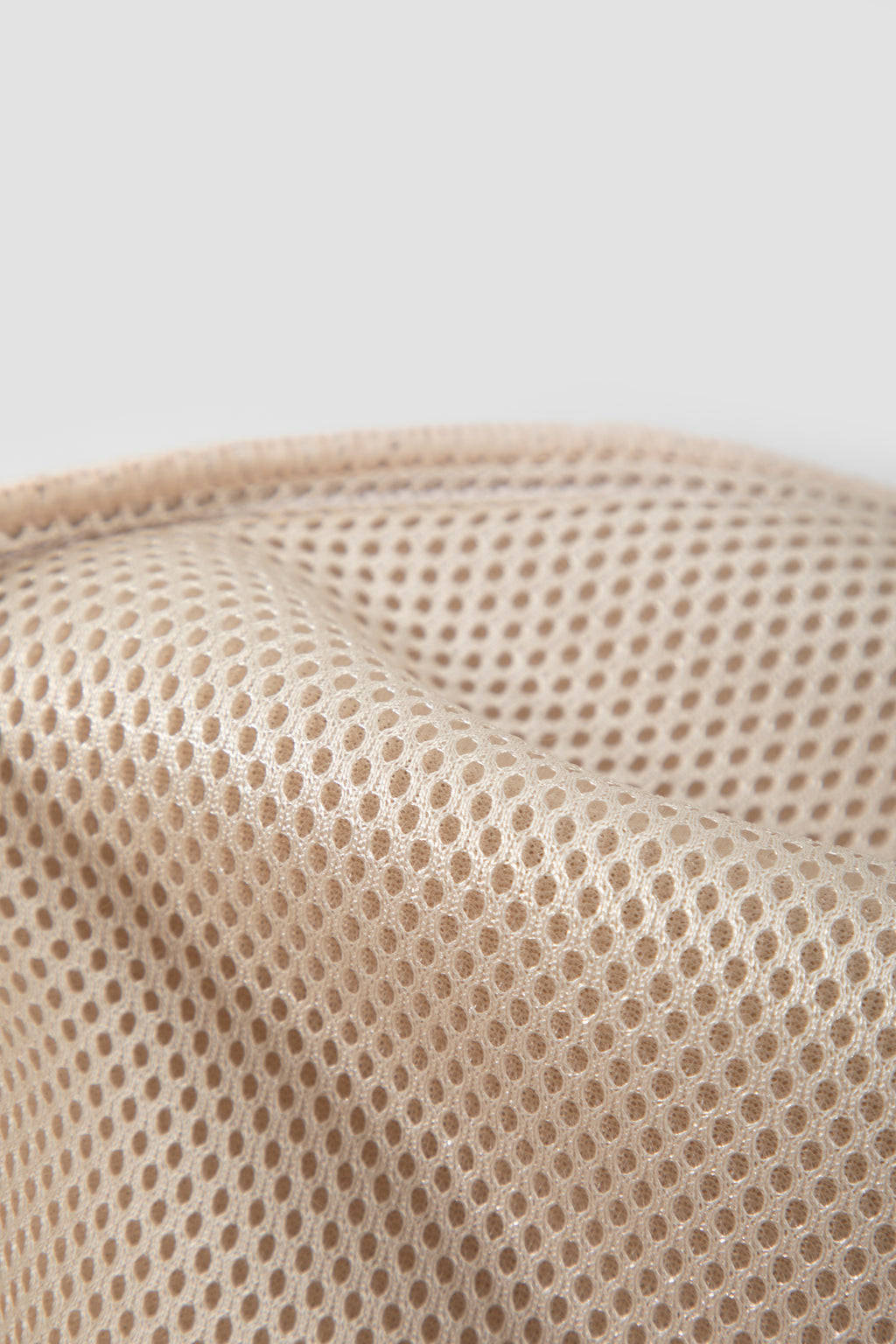 Close-up of beige textured fabric on a light gray background
