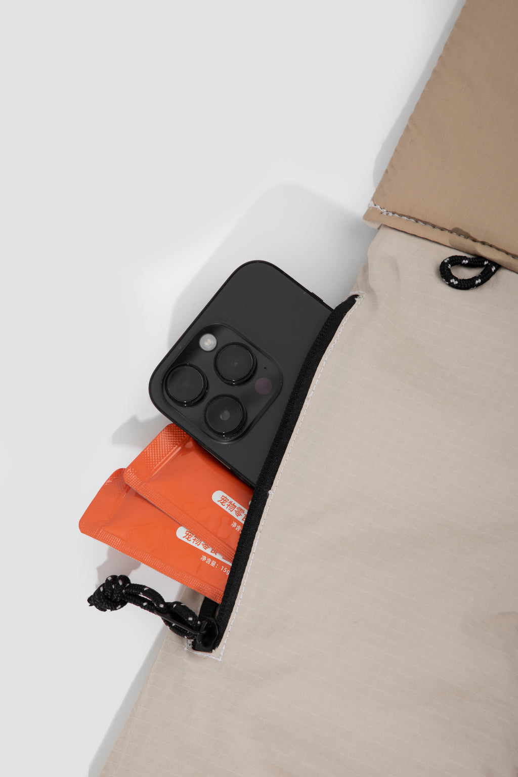 Close-up of a phone case with a camera lens and orange accents on a light background