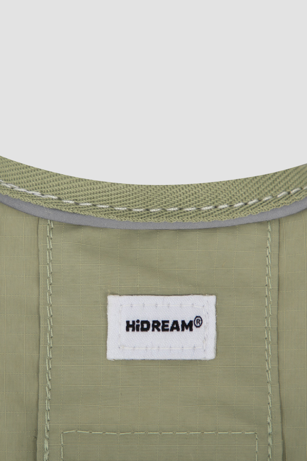 Close-up of a green fabric with a 'HIDREAM' label on a white background