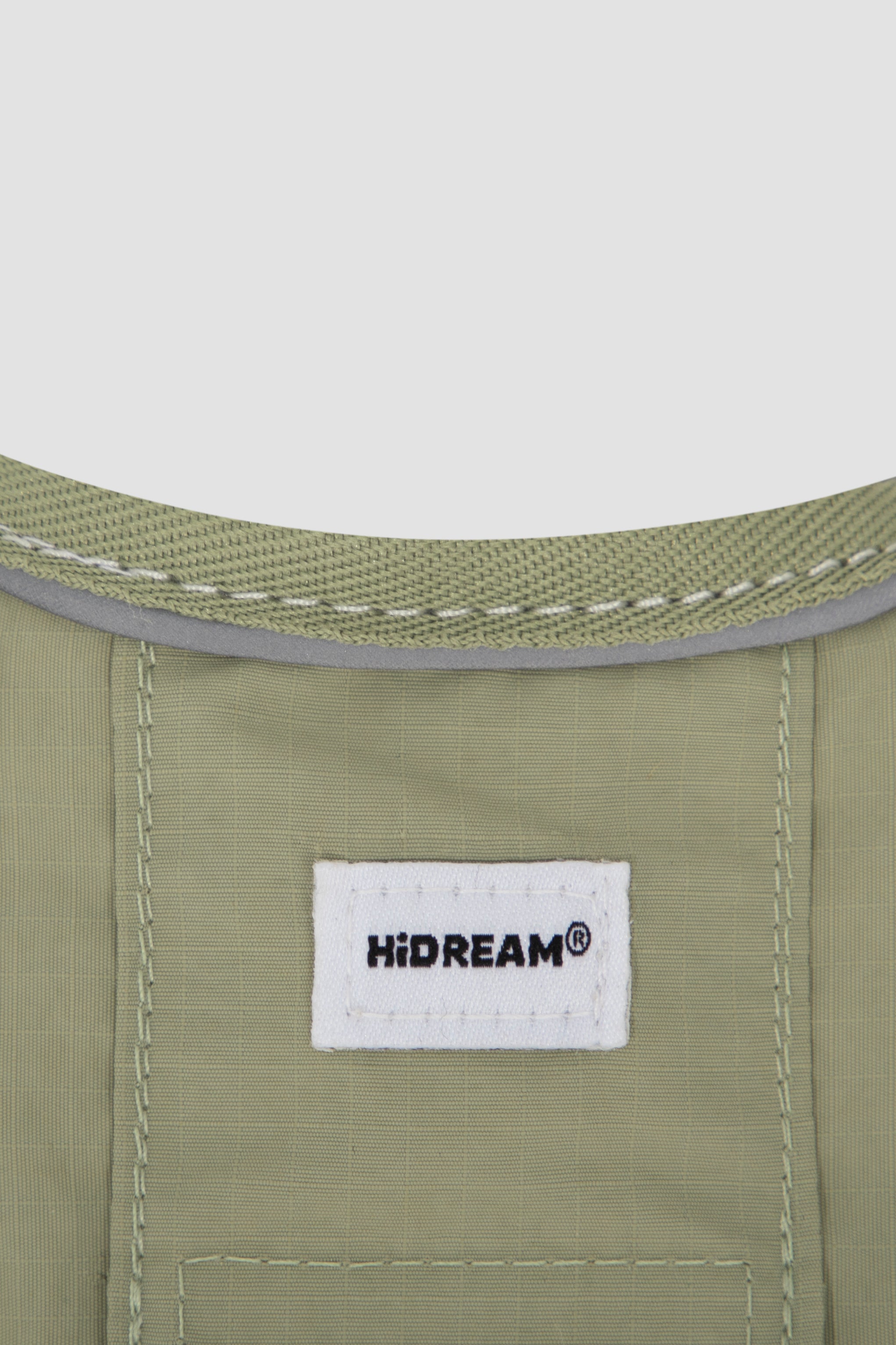 Close-up of a green fabric with a 'HIDREAM' label on a white background