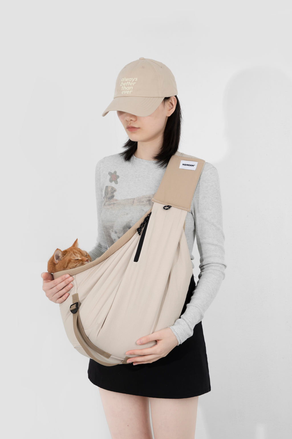 Person holding a baby in a sling against a white background