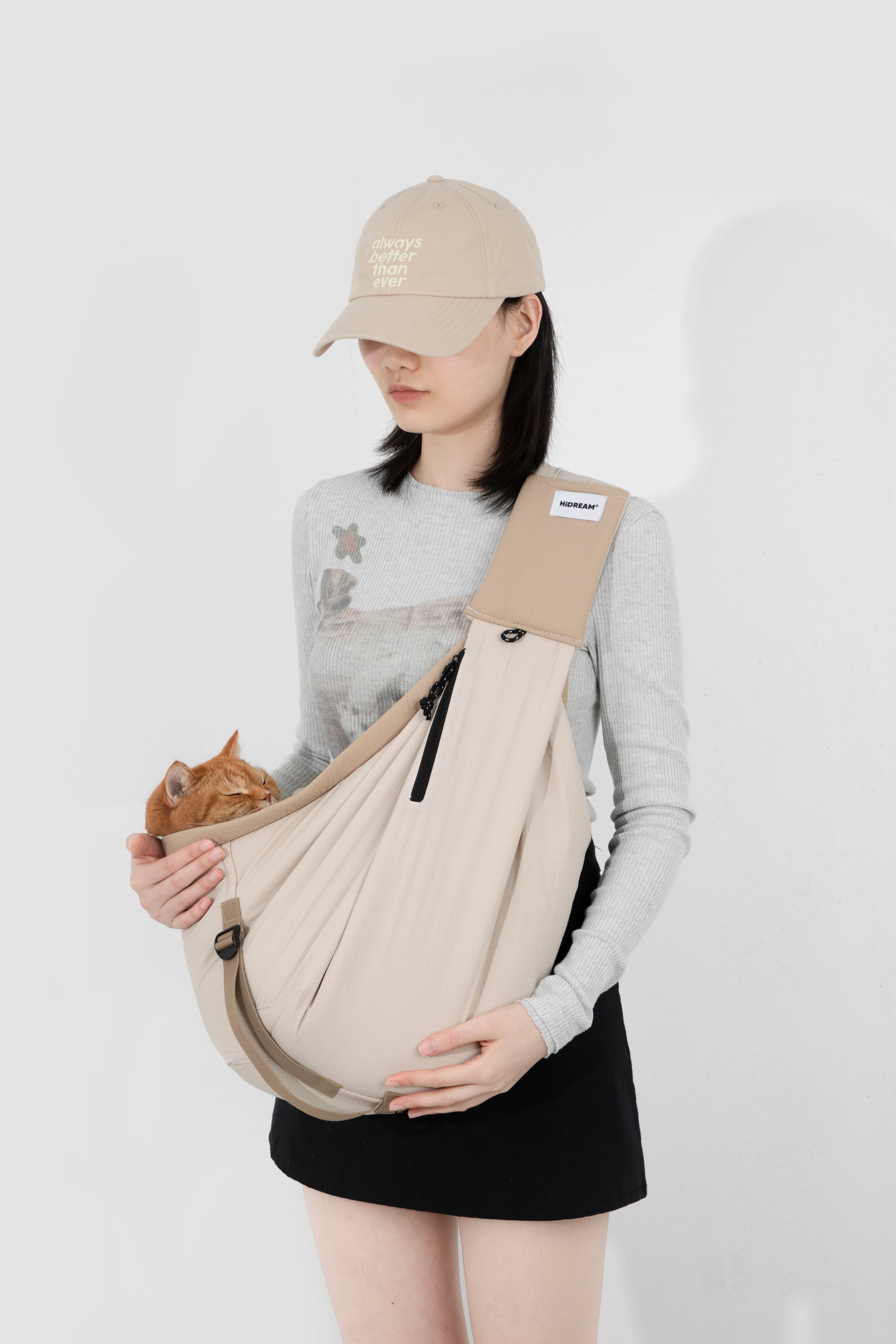 Person holding a baby in a sling against a white background