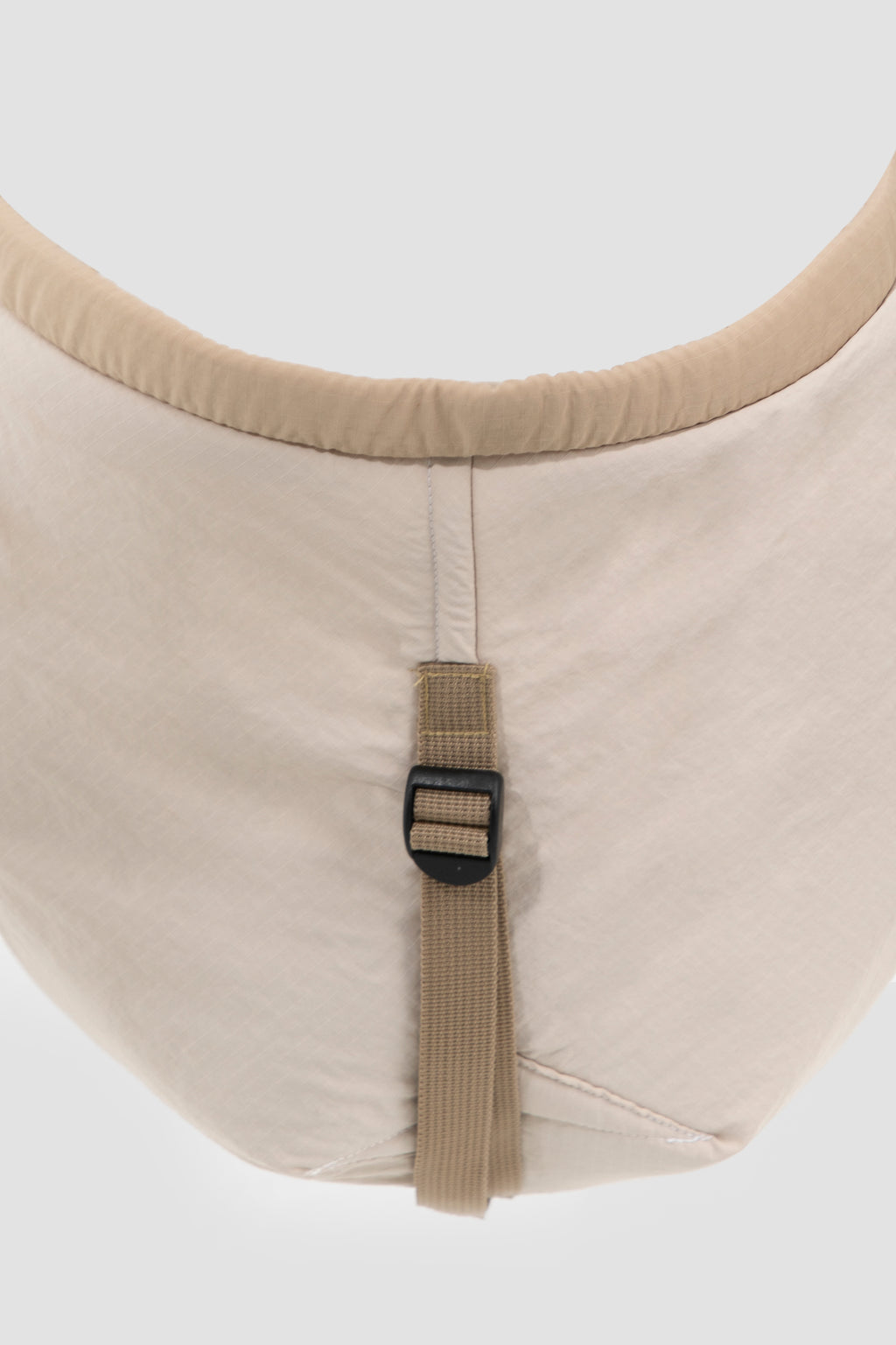 Close-up of a beige seat with a strap on a white background