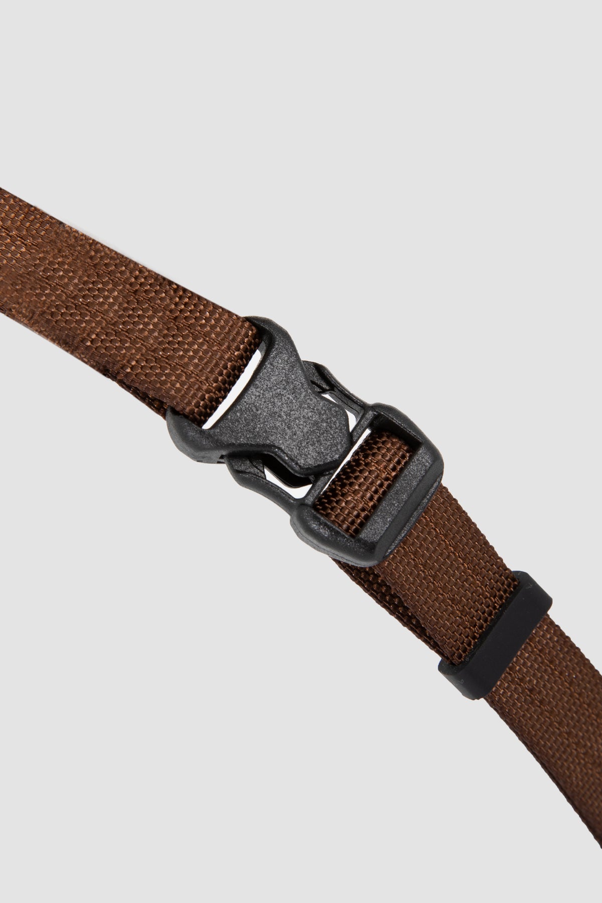 Brown belt with a black buckle on a light gray background