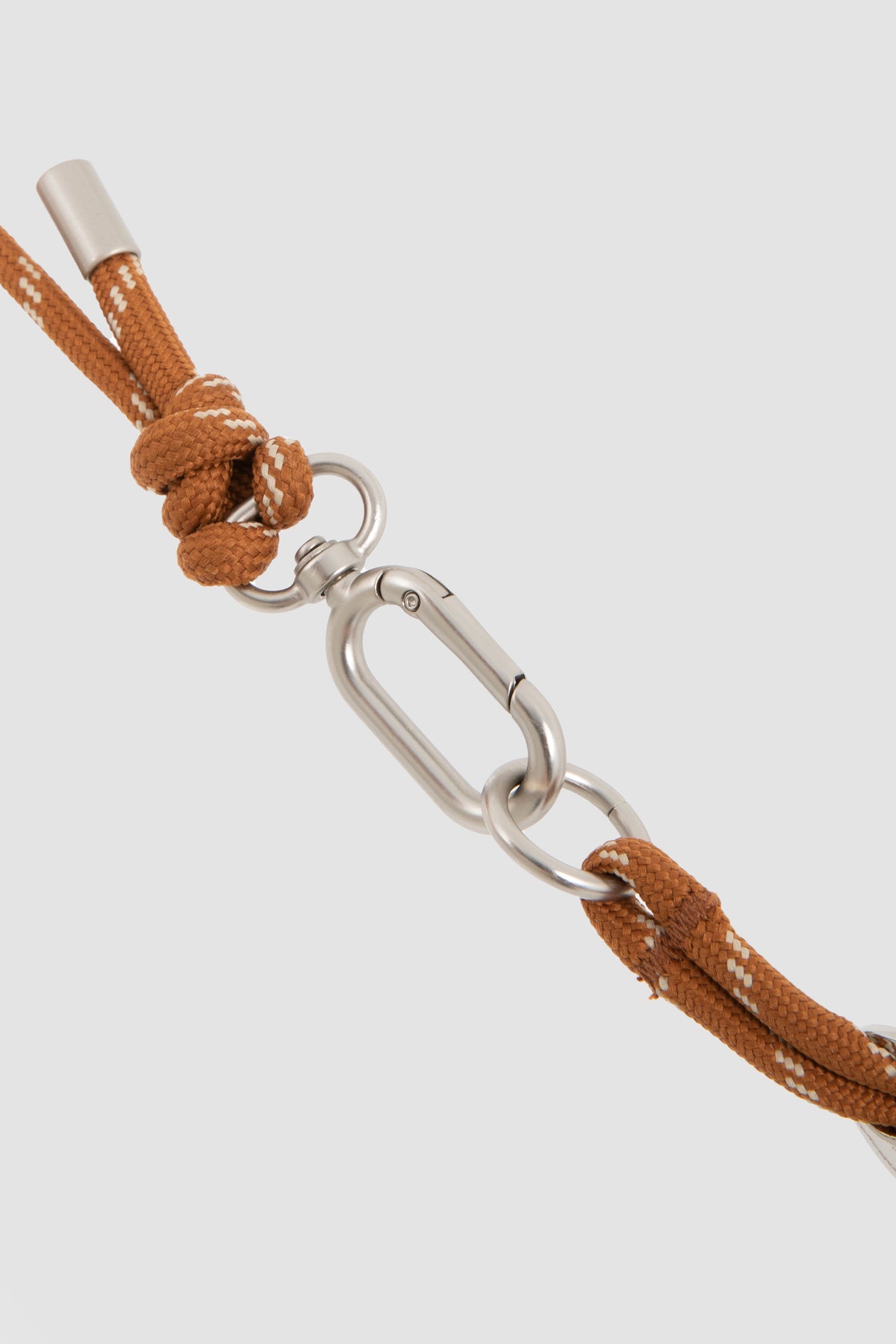 Brown braided cord with a silver clasp on a light gray background