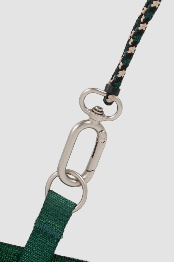 Close-up of a green strap with a metal carabiner on a white background