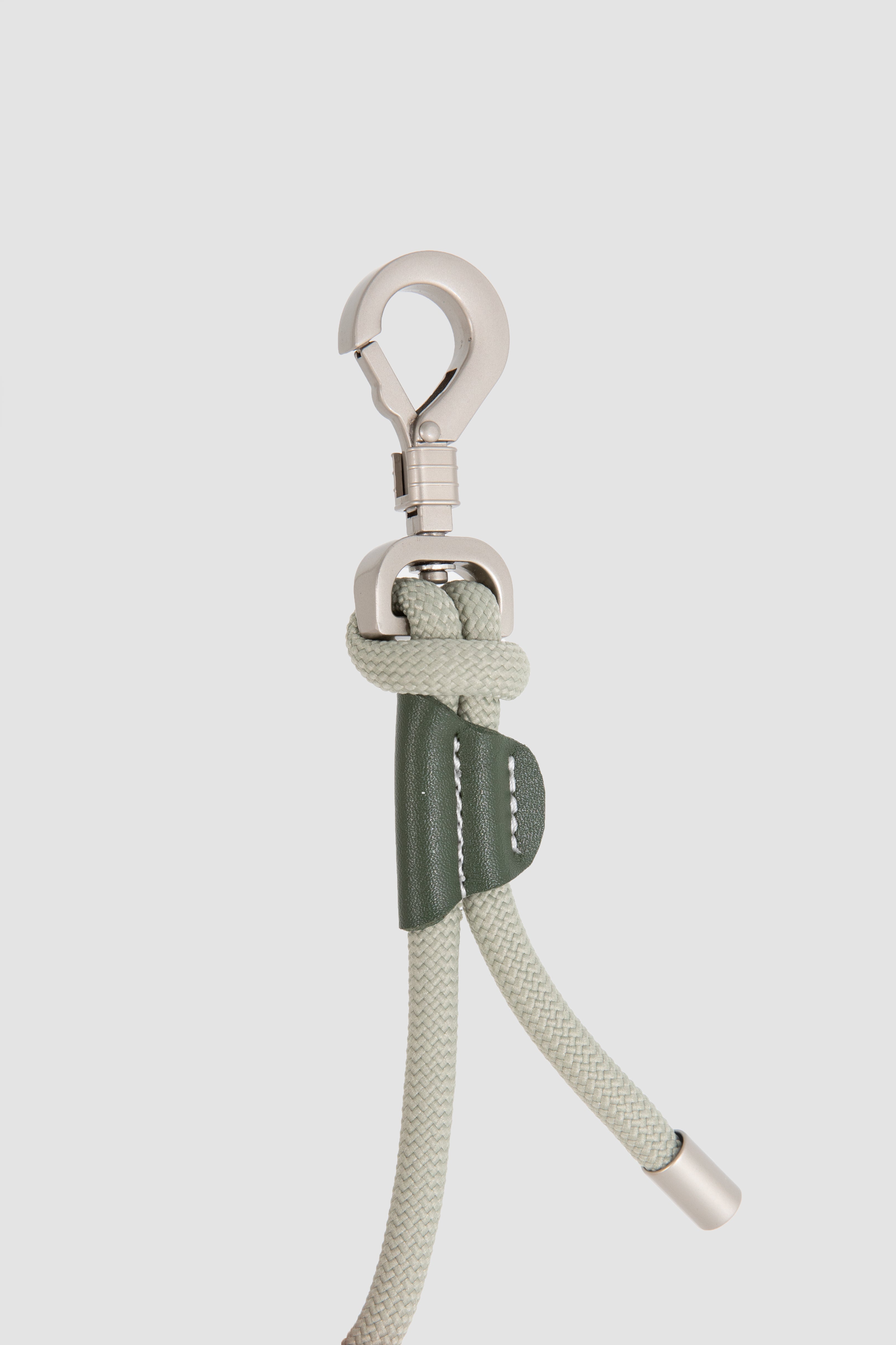 Buckle with rope and metal clip on a light gray background