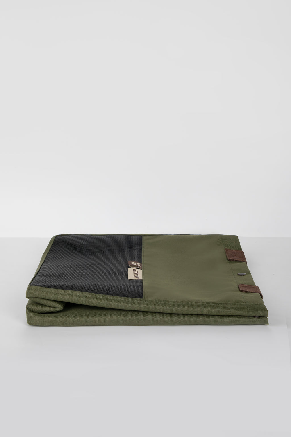 Green and black fabric roll with leather straps on a white background