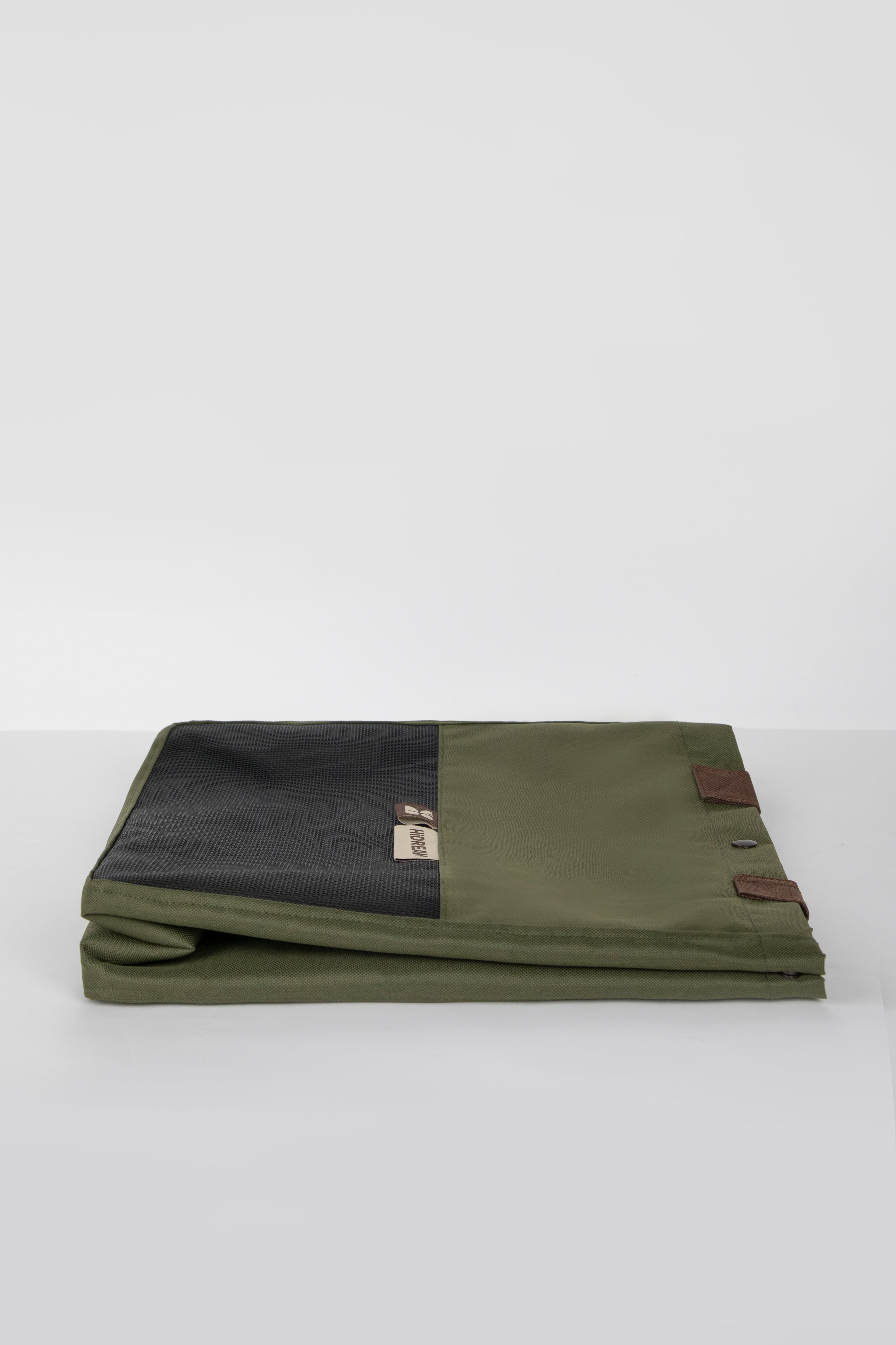 Green and black fabric roll with leather straps on a white background