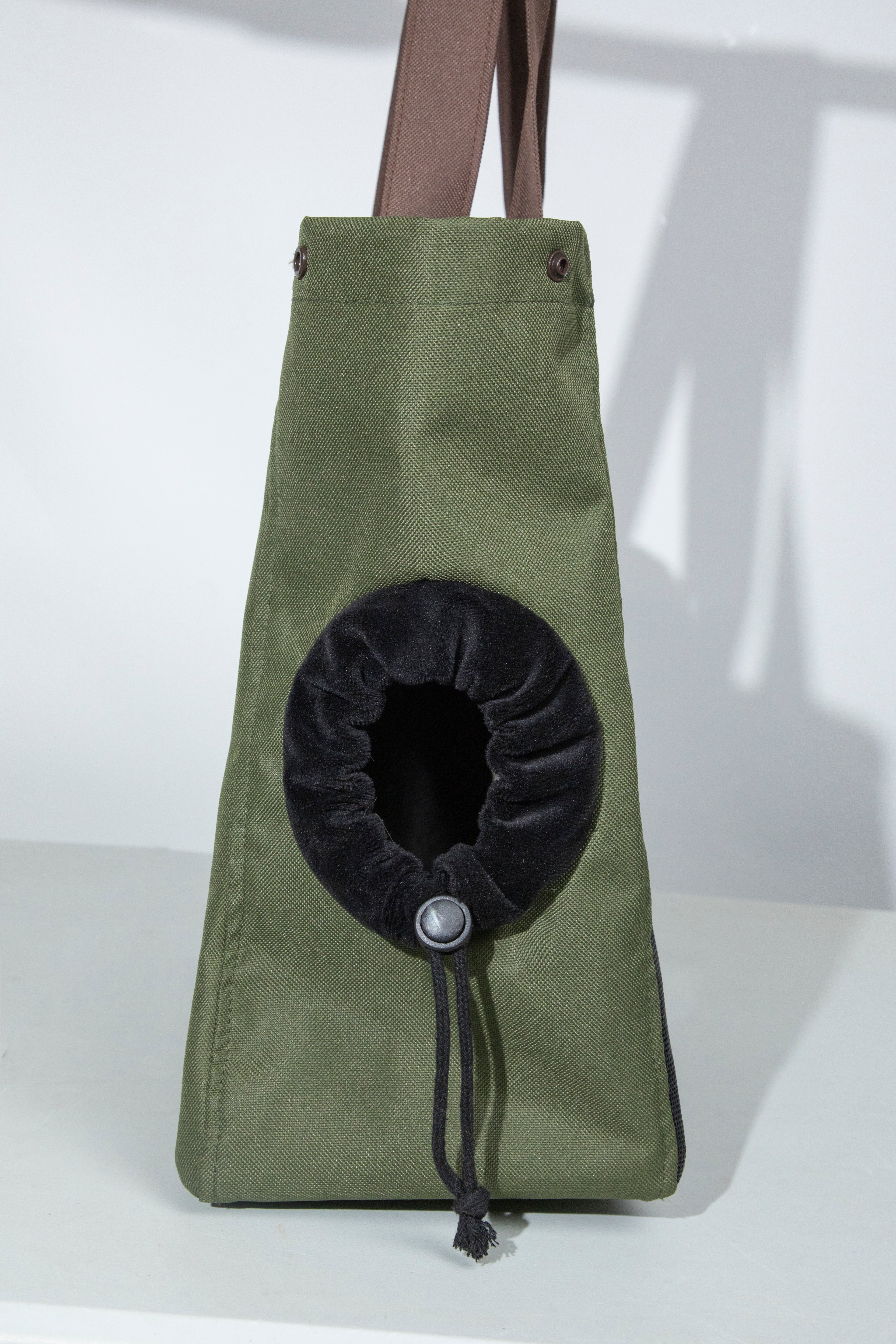 Green tote bag with a black circular pouch on a white background
