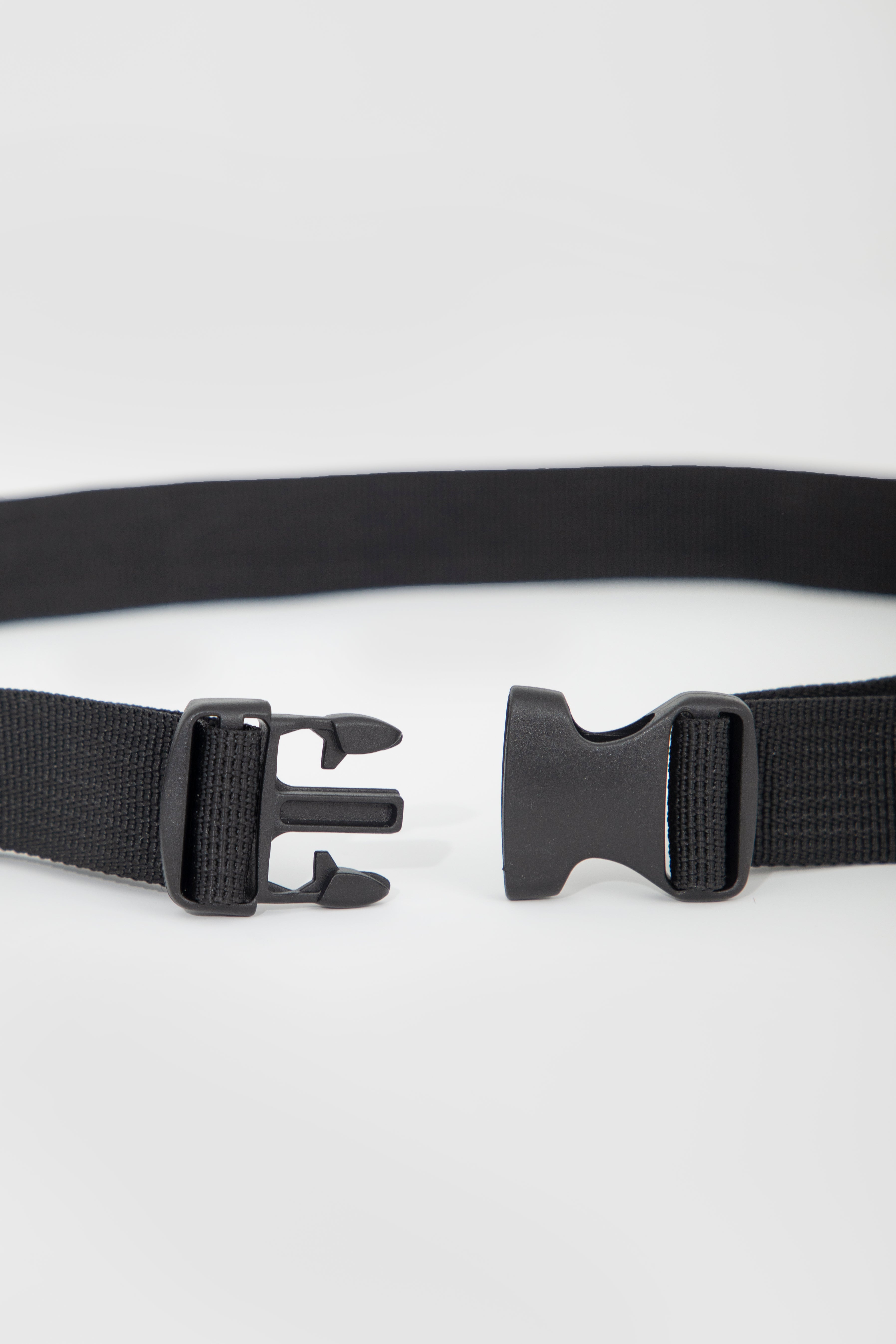 A close-up of a black web belt showing both sides of the buckle mechanism against a light gray background.
