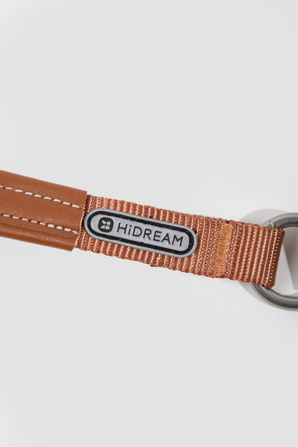 Brown dog leash with a HiDREAM label on a white background