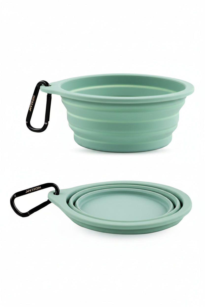Two collapsible green bowls with carabiners on a white background