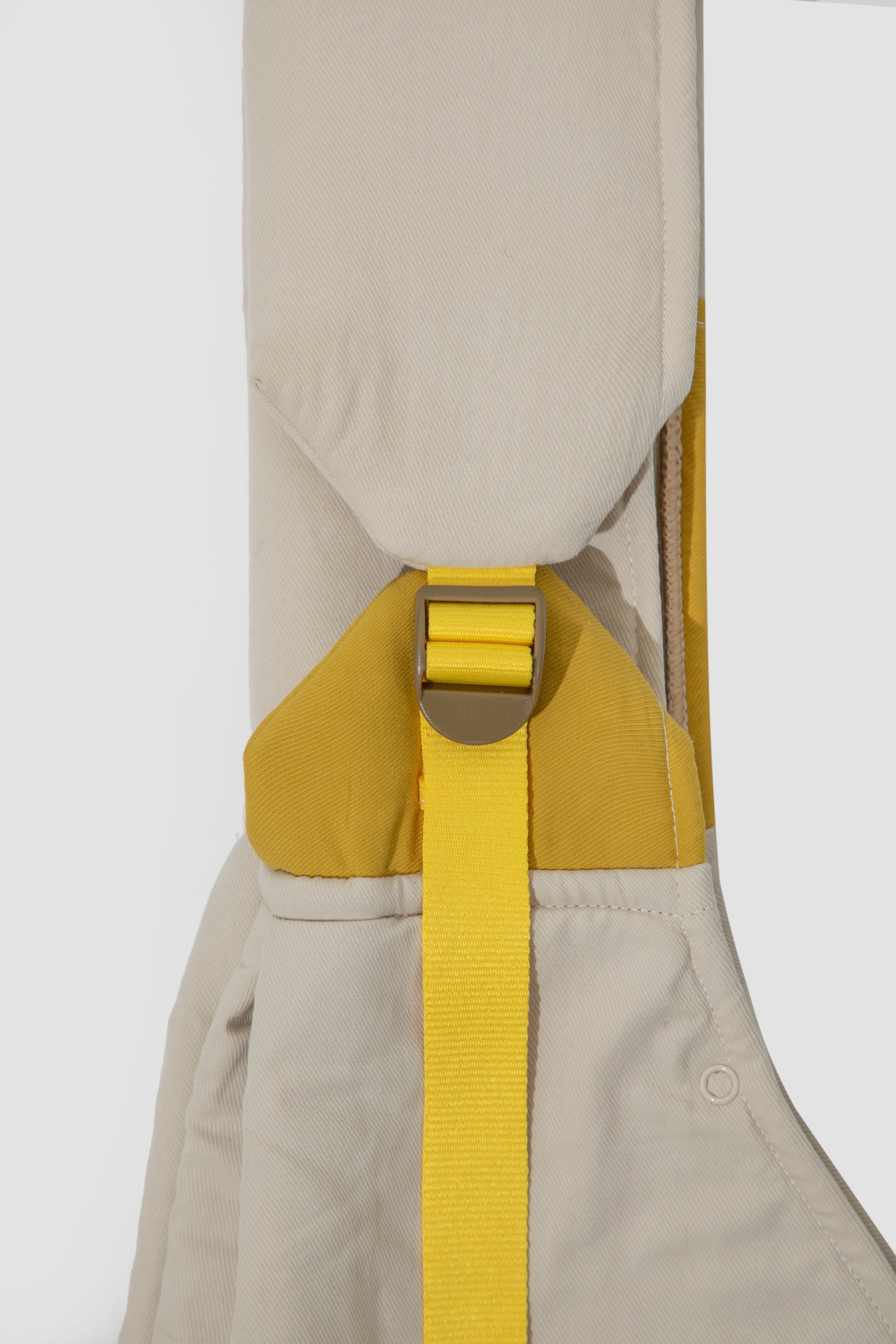 Beige overalls with a yellow strap on a white background