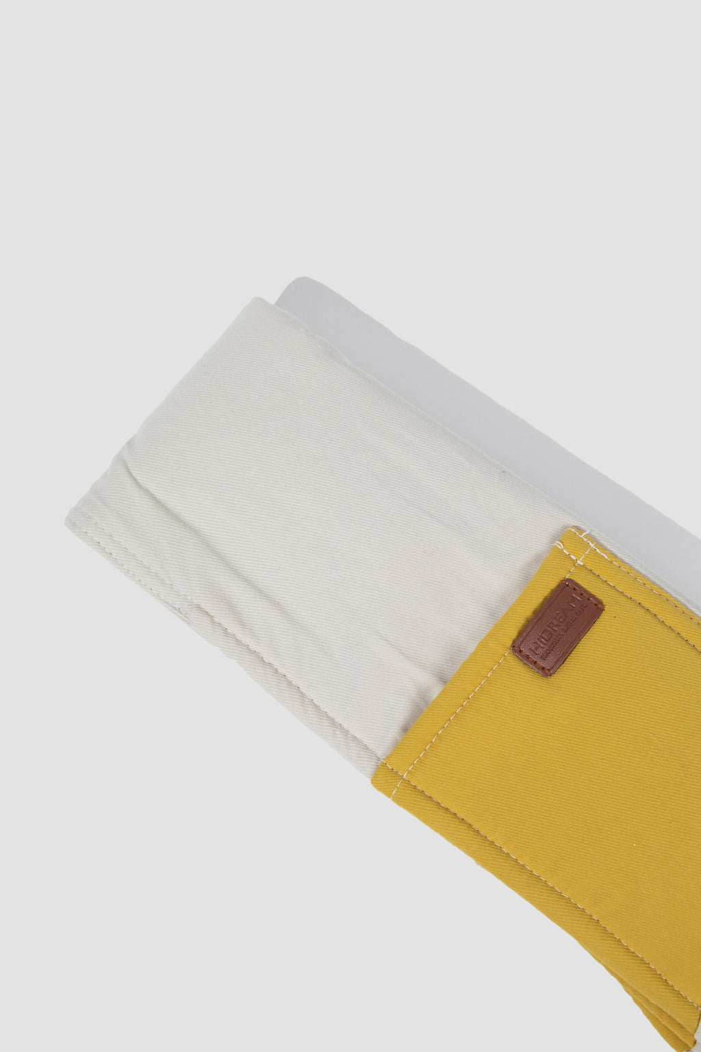 Close-up of a yellow wallet with a brown patch on a white background